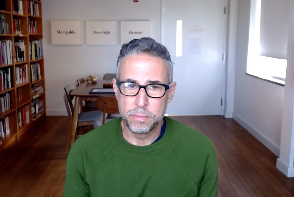 Image of man with grey hair, glasses, and a green sweater.