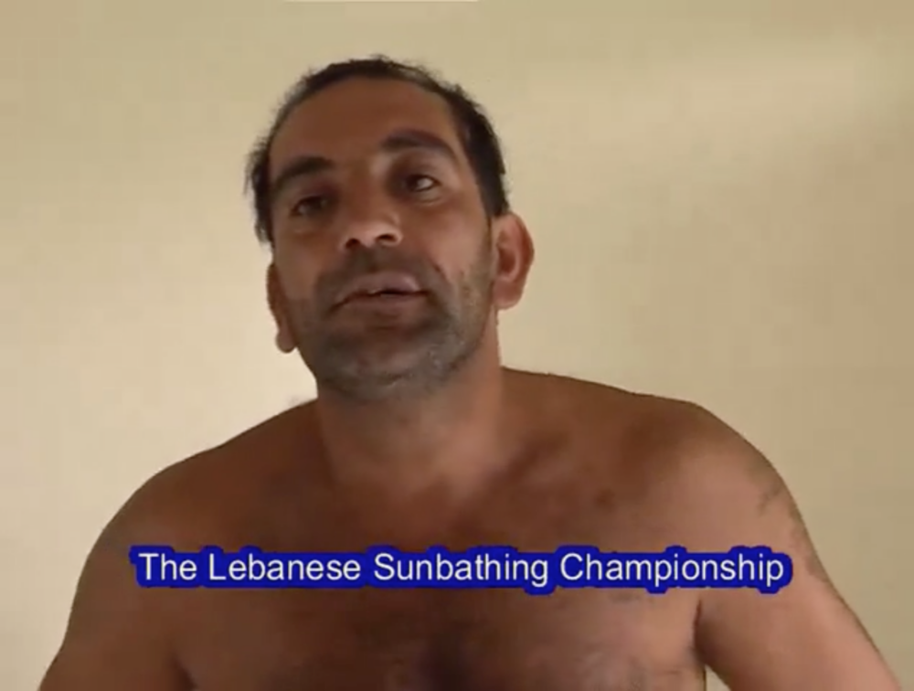 Image of shirtless tan man with dark hair in front of yellowish background with text that read "The Lebanese Sunbathing Championship" as subtitles.