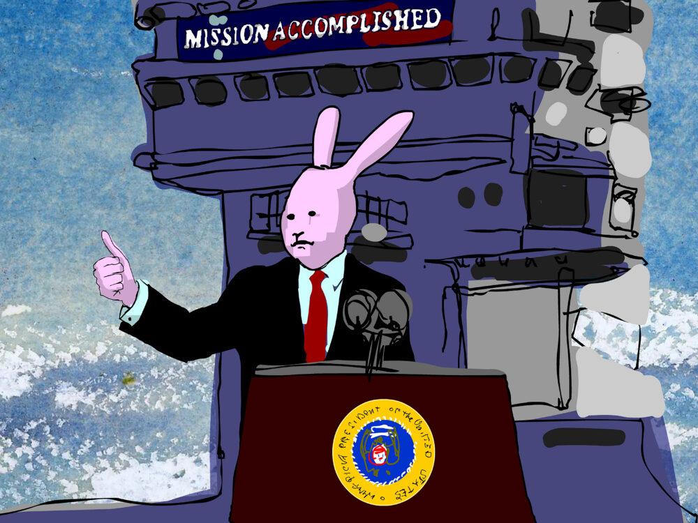 Animated pink bunny figure in blue suit standing behind a podium giving a thumbs up in front of the helm of a ship with a banner upon it that reads "mission accomplished"